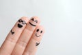 Fingers with drawings of happy faces