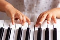 Fingers of a girl in a white dress playing the keys of an electronic piano, synthesizer, close up Royalty Free Stock Photo