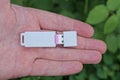 fingers on the hand hold one white small plastic compact flash drive Royalty Free Stock Photo