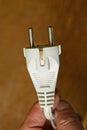 Fingers on hand holding white old electrical plug socket with cable Royalty Free Stock Photo