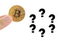 fingers hold bitcoin. Question marks around the coin. Unknown Crypto currency exchange rate