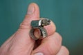 Fingers hold one gray metal clamp with a bolt Royalty Free Stock Photo