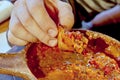 Fingers hold a piece of bread dipped in meat sauce, close-up Royalty Free Stock Photo