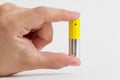 Fingers holding aa size alkaline battery