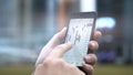 Hands using a mobile phone to check stock market data