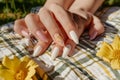 fingers splayed on a picnic blanket showcasing nails