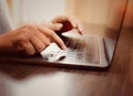 Fingers to keyboard on the laptop to working from home with business communications working with selective focus on Royalty Free Stock Photo