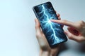 Fingers touch the phone with the image of lightning on the screen. Space for text. Royalty Free Stock Photo