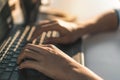 Fingers typing on the computer laptop keyboard in morning time, Selective focus Royalty Free Stock Photo