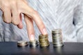 Fingers walk on piles of coins, symbolizing financial growth and progress in business. Concept of career growth and wage increases Royalty Free Stock Photo