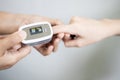 Fingertip pulse oximeter on the finger of young woman measuring heart rate pulse checking oxygen saturation SpO2 level in the Royalty Free Stock Photo