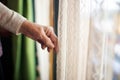 fingertips tracing the patterns on a lace curtain in a home store