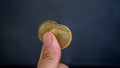 Fingers and coins in heart shape, in black background