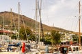 FINIKAS, Greece. Dock in Finikas Port on Siros Island, Greece, with row of colorful sailboats and masts and greek houses.