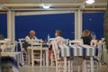 Typical atmosphere of a Greek tavern with customers having dinner near the sea in Finikounda in Messenia, Greece Royalty Free Stock Photo