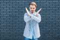 Finish, this is the end. Portrait of serious handsome young blonde man in casual style standing with x sign and showing closed Royalty Free Stock Photo