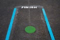 Finish line and Green spot on tarmac floor in School playground,Blue line and Green Circle with Finish word on pavement at public Royalty Free Stock Photo