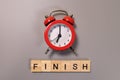 Finish word and alarm clock on gray background