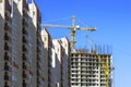 Finished Apartment Building and a New High-Rise Building Construction Site with Yellow Cranes against Blue Sky. Real Estate, Royalty Free Stock Photo