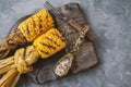 finished corn on the grill lies on a beautiful wooden board. Homemade corn dish. Top view, copy space Royalty Free Stock Photo