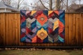 finished quilt draped over a wooden fence outdoors