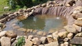 finishing a pond in the garden, surrounded by stones to make a natural pond