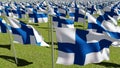 Finland flags waving in green field Royalty Free Stock Photo