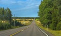 Summer highway, yellow fields with trees on the sides of the road