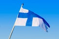 Finland national flag waving on the wind against clear blue sky. Finnish flag on flagpole Royalty Free Stock Photo
