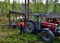 Finland/Wood logging: Tractor with Hydraulic Grabber Lifting Timber