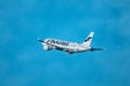 A Finnair Airbus A320 flies against a bright blue sky