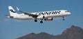Finnair Airlines flies in the blue sky. Landing at Tenerife Airport