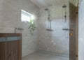 Modern bathroom with wooden sauna, open showers and marble walls and floors. Royalty Free Stock Photo