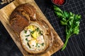 Finnish Creamy fish soup with salmon, trout, potatoes served in bread. Black background, top view