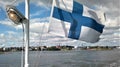 Finnish flag at the stern of the ship against the sky and the view of Helsinki.