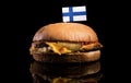 Finnish flag on top of hamburger isolated on black Royalty Free Stock Photo