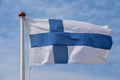 Finnish flag waving against blue sky Royalty Free Stock Photo