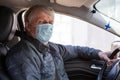 Finnish man wearing face mask while driving the car, senior male driver Royalty Free Stock Photo