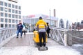 Finnish postman carries yellow box with correspondence and newspapers on street of city Helsinki, postal service concept, delivery