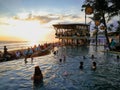 Finns Beach Club, A vacation destination in Bali with a lively beach party, a palm tree architecture, and a breathtaking sunset
