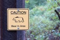 Bear warning sign beside hiking trail in forest