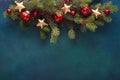 Fir branch with Christmas decoration on a dark blue-green painted wooden background. Royalty Free Stock Photo