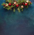 Fir branch with Christmas decoration on a dark blue-green painted wooden background. Flat lay.  New Year background with place for Royalty Free Stock Photo