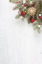 Fir branch with Christmas decoration on white shabby wooden board with copy space for text. Royalty Free Stock Photo