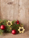 Fir branch with Christmas decorations on rustic wooden background
