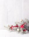 Fir branch with Christmas decorations on white rustic wooden background with copy space for text Royalty Free Stock Photo