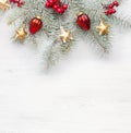 Fir branch with Christmas decorations on the white shabby wooden board with empty space for text. Flat lay Royalty Free Stock Photo