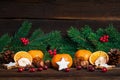 Fir branch and Cinnamon cookies nuts and tangerines on wooden background