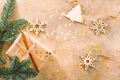 Fir branch, wooden toys and Christmas gift box on a beige textured background with gold stars confetti Royalty Free Stock Photo