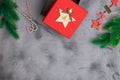 Fir branches on concrete gray background with red gift box. Christmas and New Year decoration. Space for text flat lay. Royalty Free Stock Photo